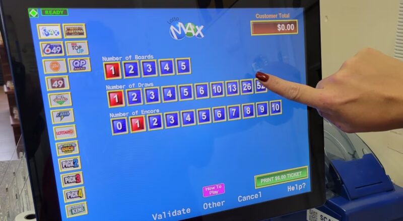 A clerk hands prints off a customer's Lotto Max ticket at a gas station north of Newcastle, Ontario on Thursday Oct. 6, 2022. THE CANADIAN PRESS/Doug Ives